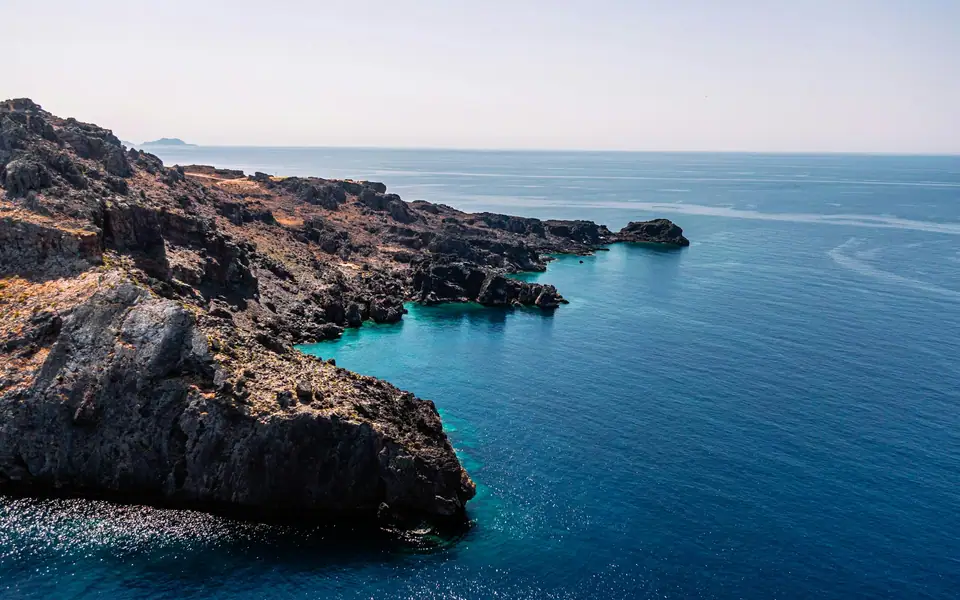 Rocky coastline beside blue water at Plakias, Crete